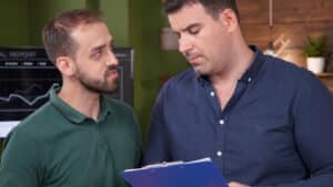 two men looking at a clipboard
